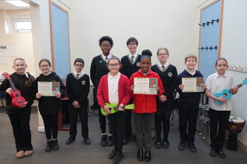 WPT Awarded Music Mark - students holding certificates and instruments